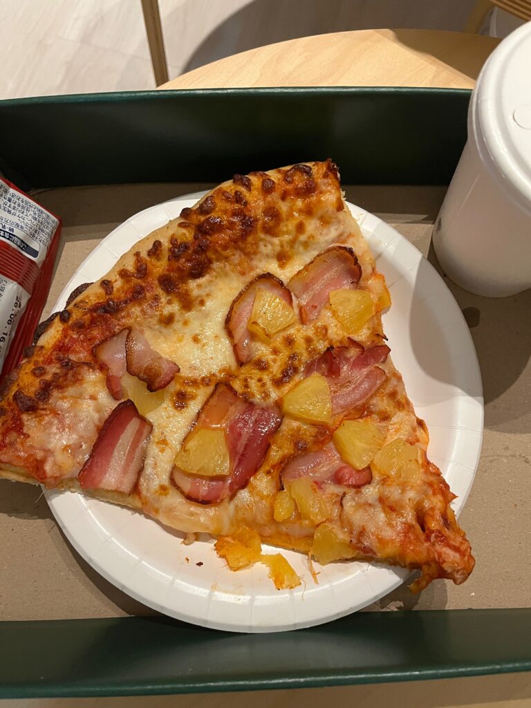 ハワイアンピザを楽しんで食べている家族