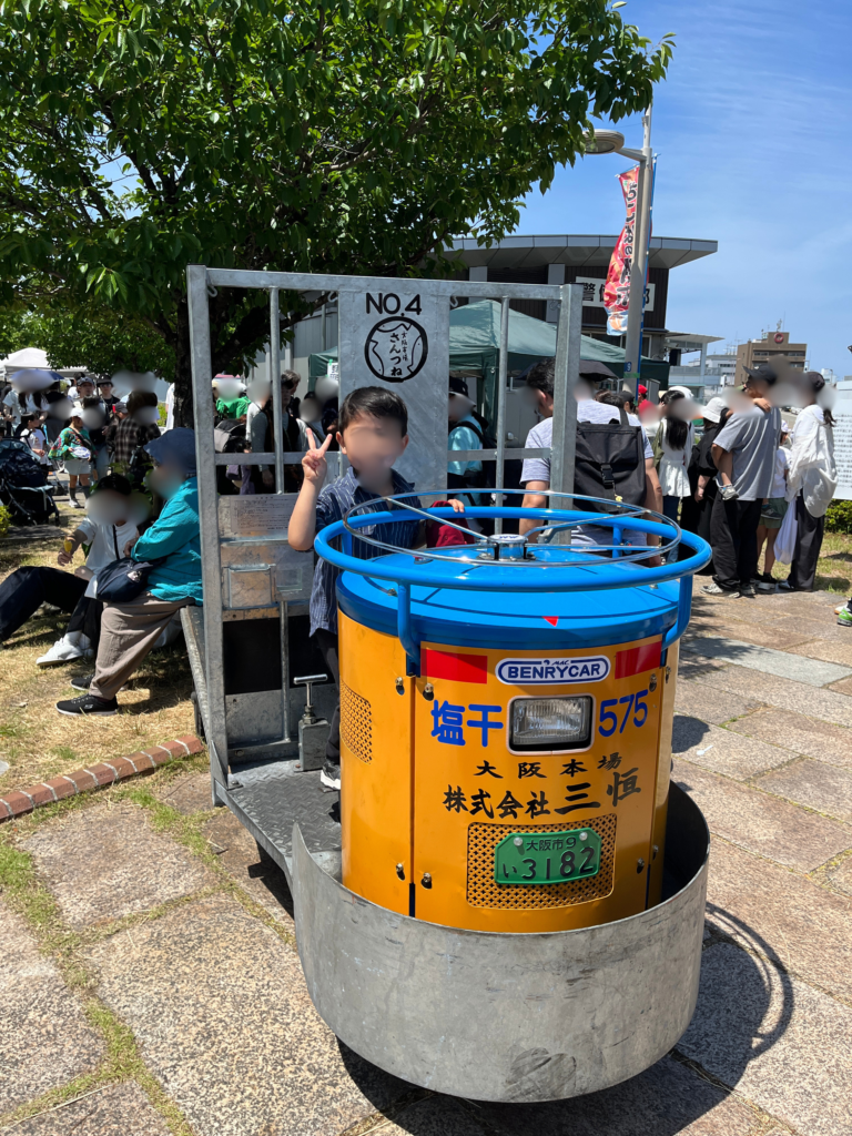 市場ならではの乗り物で記念撮影する子供