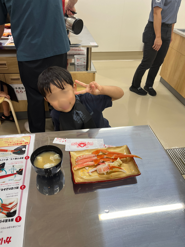 カニの身とみそ汁を堪能する子供